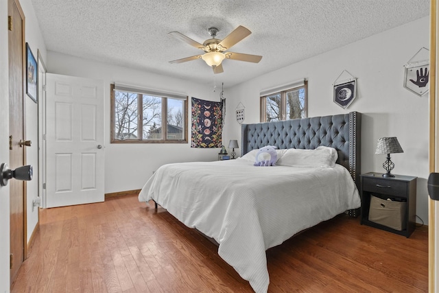 bedroom featuring a textured ceiling, wood-type flooring, and ceiling fan