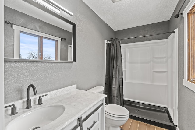 bathroom with vanity, curtained shower, a textured ceiling, and toilet