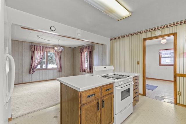 kitchen with light carpet, white appliances, and decorative light fixtures