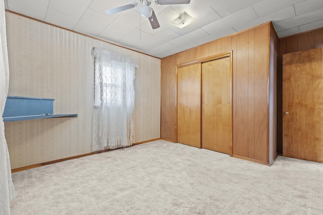 unfurnished bedroom featuring ceiling fan, light colored carpet, and a closet