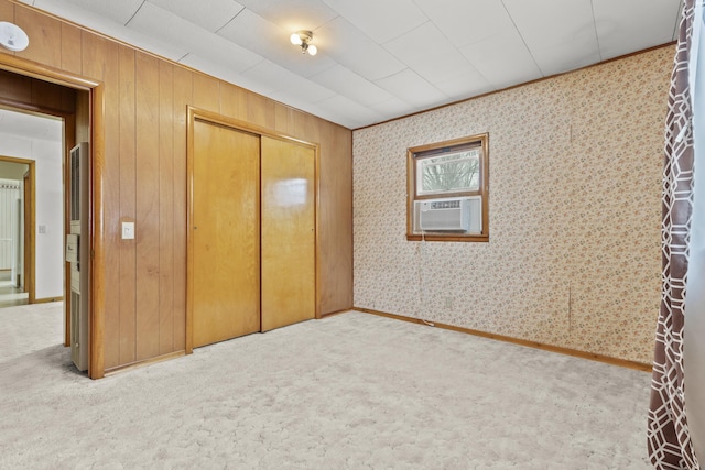 unfurnished bedroom featuring cooling unit, carpet floors, and a closet