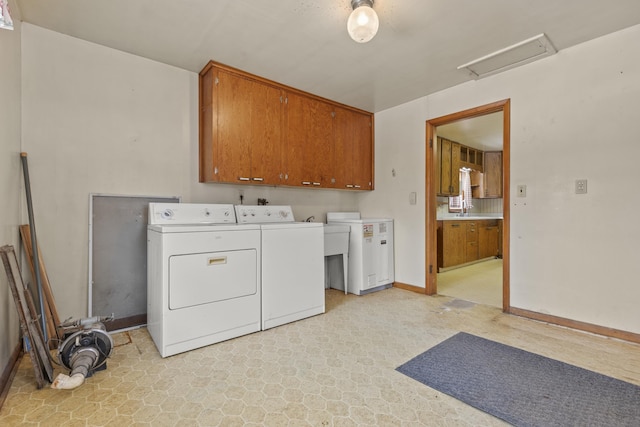 laundry room with cabinets, separate washer and dryer, and sink