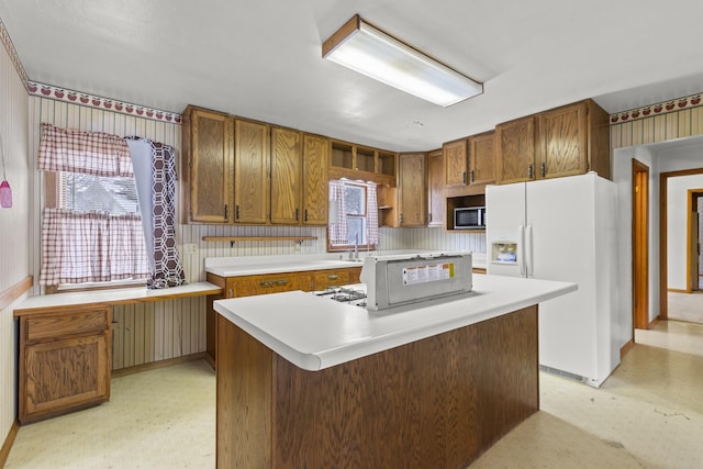 kitchen featuring white refrigerator with ice dispenser, plenty of natural light, and a kitchen island