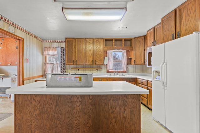 kitchen with sink, white fridge with ice dispenser, and a center island