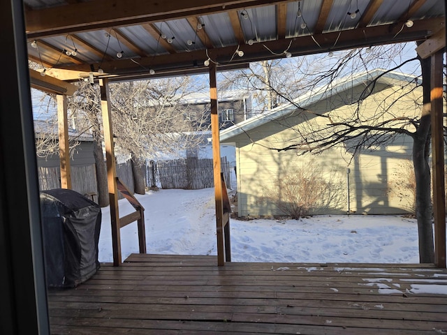 snow covered deck with a grill