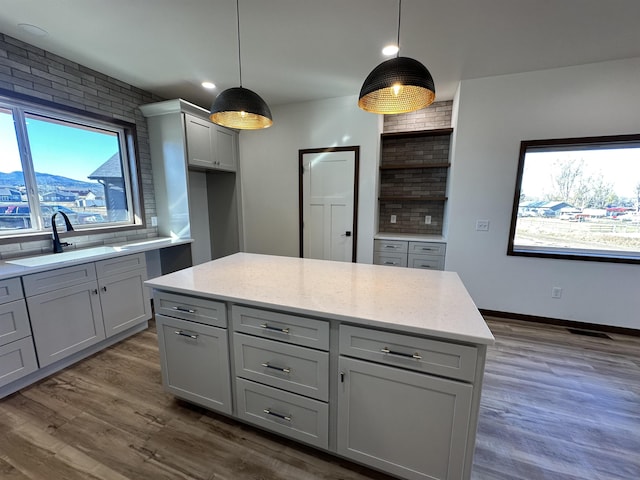 kitchen featuring pendant lighting, sink, gray cabinetry, and decorative backsplash