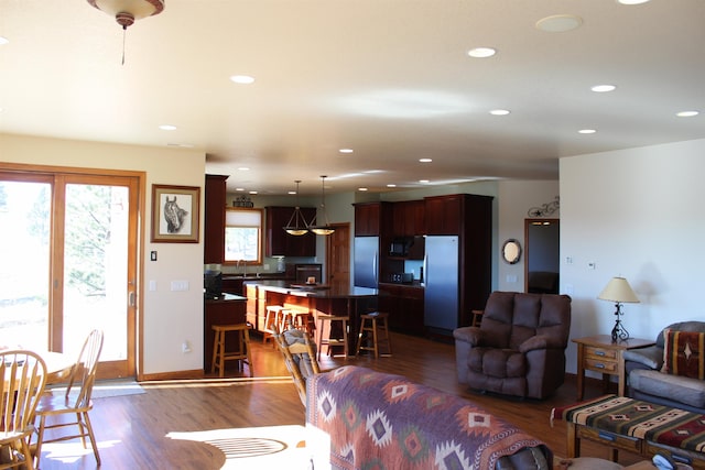 living room with recessed lighting, baseboards, and dark wood-type flooring