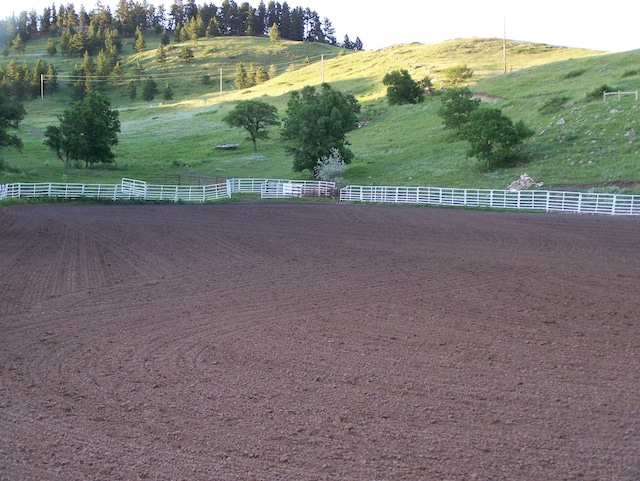 view of yard with a rural view and fence