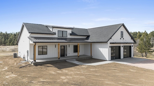 modern inspired farmhouse featuring cooling unit, a garage, and a porch