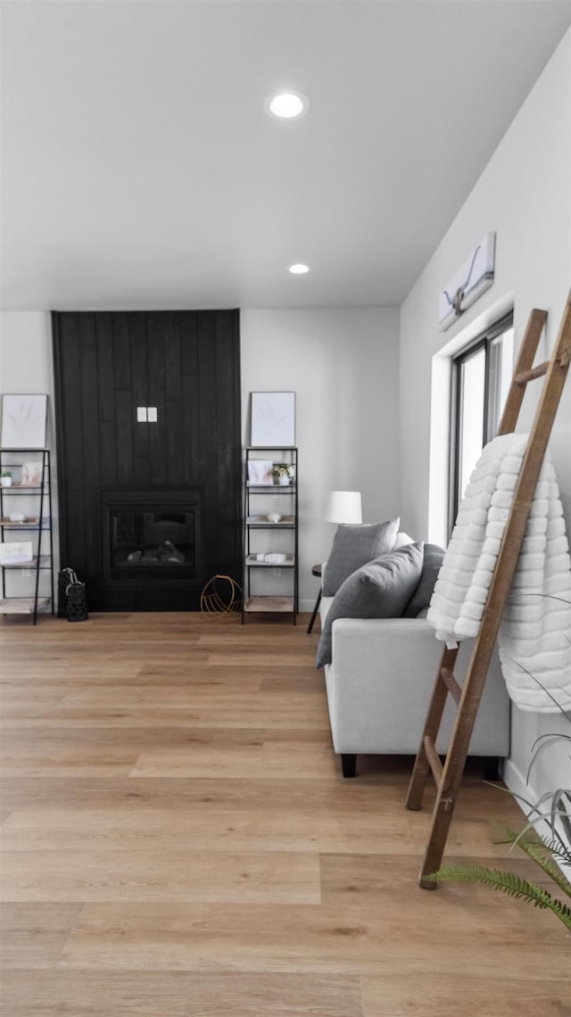 living room with a large fireplace and light hardwood / wood-style floors