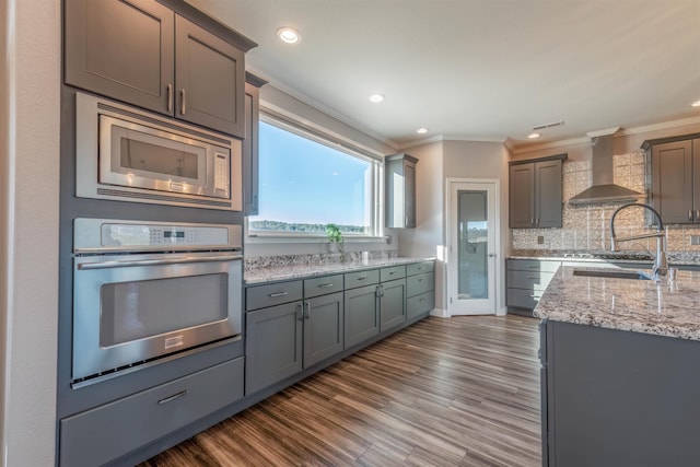 kitchen featuring crown molding, appliances with stainless steel finishes, dark hardwood / wood-style floors, tasteful backsplash, and wall chimney exhaust hood