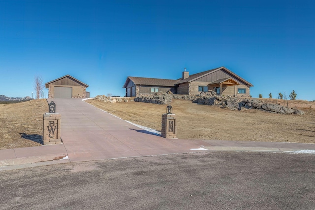 single story home with a garage, an outdoor structure, and a front yard