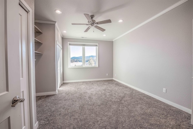 unfurnished bedroom featuring ceiling fan, ornamental molding, and dark colored carpet