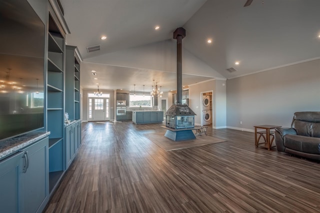 unfurnished living room with dark wood-type flooring, high vaulted ceiling, ceiling fan with notable chandelier, and a wood stove