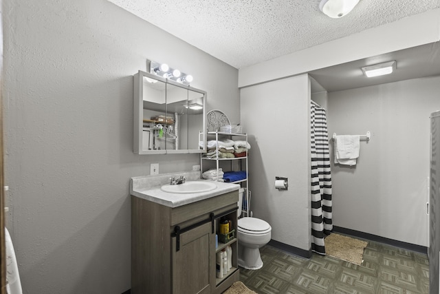 bathroom featuring vanity, toilet, and a textured ceiling