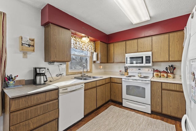 kitchen with white appliances, dark hardwood / wood-style floors, sink, and a textured ceiling