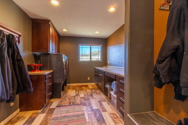 washroom featuring cabinets, washer and clothes dryer, and light wood-type flooring