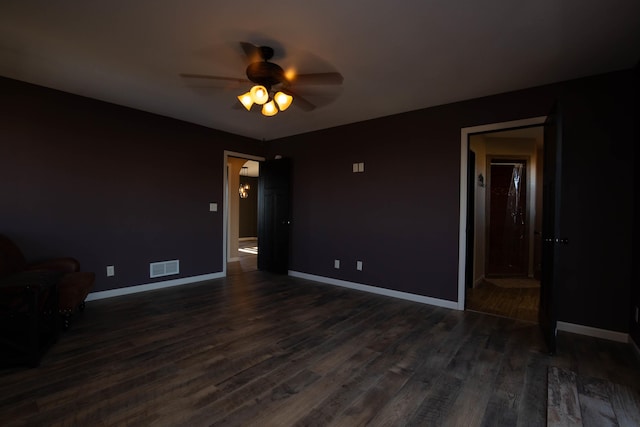 empty room featuring ceiling fan and dark hardwood / wood-style flooring