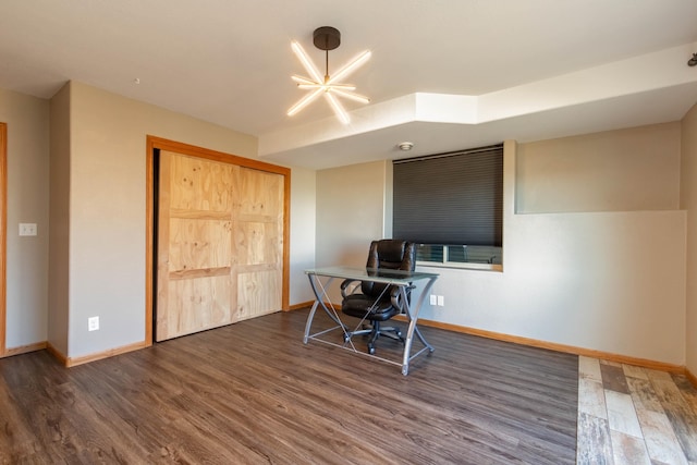 home office with dark hardwood / wood-style flooring and a chandelier