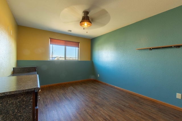 unfurnished room featuring dark hardwood / wood-style floors and ceiling fan