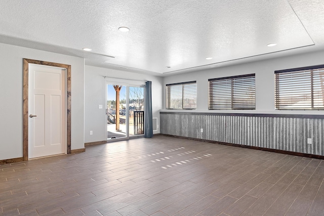 empty room featuring dark hardwood / wood-style flooring and a textured ceiling