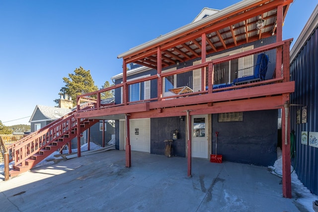 back of property featuring a wooden deck and a garage