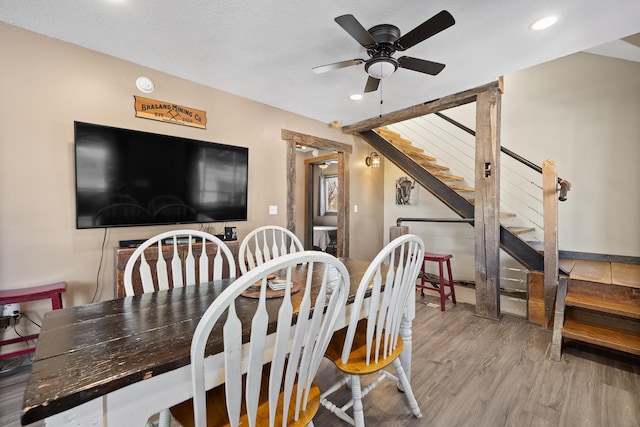 dining space featuring wood-type flooring and ceiling fan