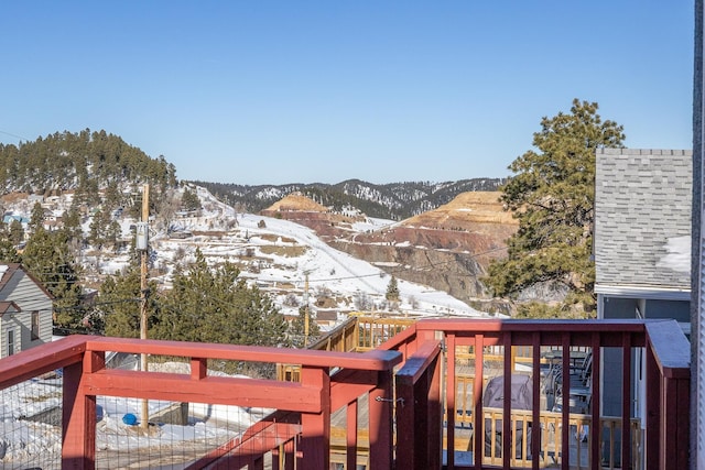 snow covered deck featuring a mountain view