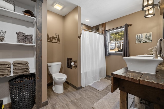 bathroom with hardwood / wood-style floors, curtained shower, and toilet