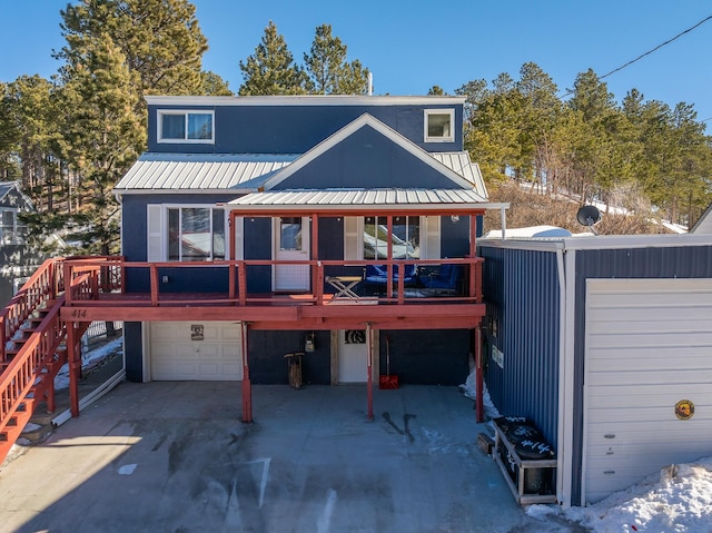 rear view of house with a wooden deck and a garage