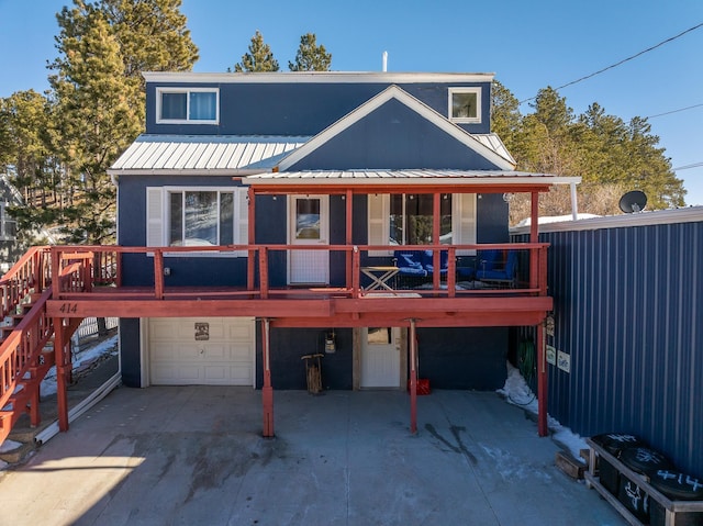 back of property with a garage and a wooden deck