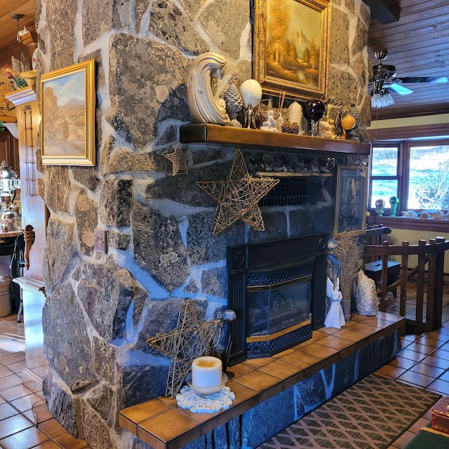 interior details featuring wood ceiling, ceiling fan, and a tiled fireplace