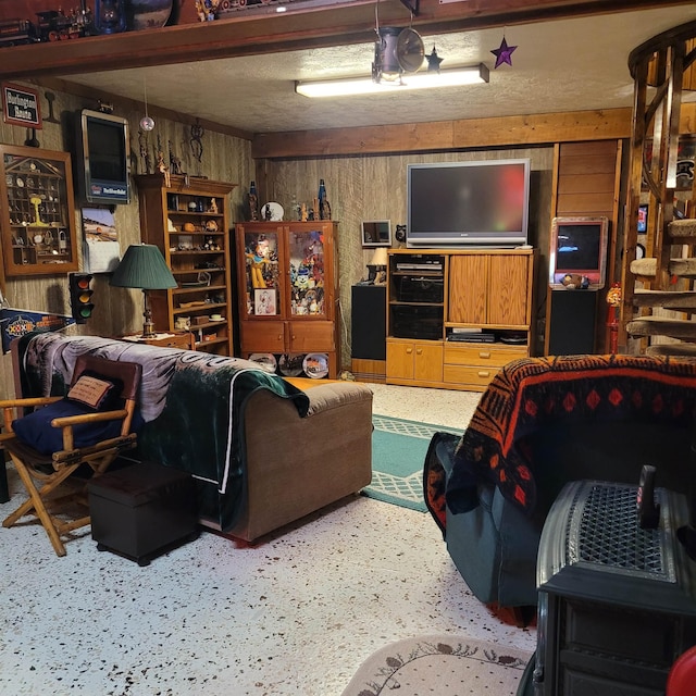 living room with a textured ceiling and wood walls