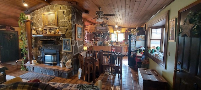 interior space with ceiling fan, lofted ceiling, a stone fireplace, and wood ceiling