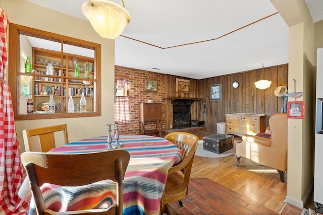 dining space with wooden walls and hardwood / wood-style floors