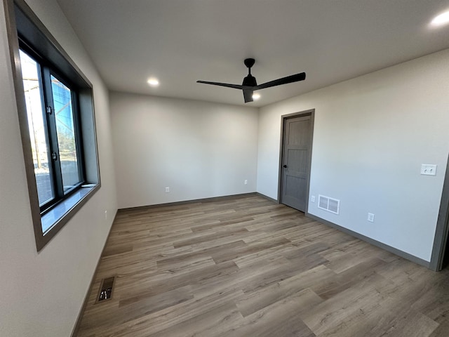 empty room with ceiling fan and light wood-type flooring