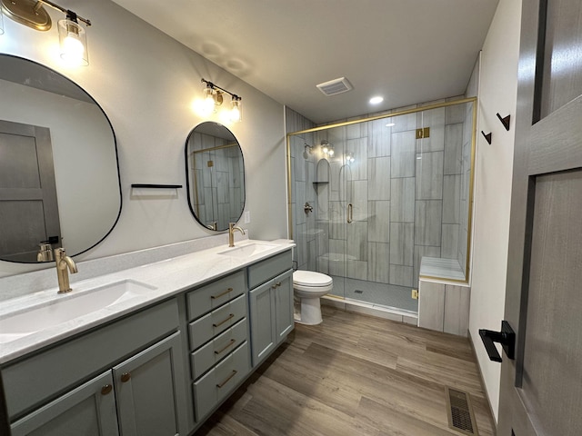 bathroom with vanity, wood-type flooring, toilet, and walk in shower