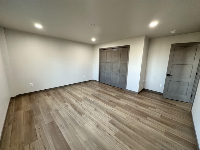 unfurnished bedroom featuring a closet and light hardwood / wood-style flooring