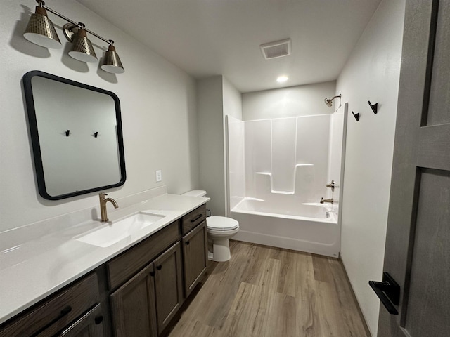 full bathroom with vanity, wood-type flooring, shower / bathtub combination, and toilet