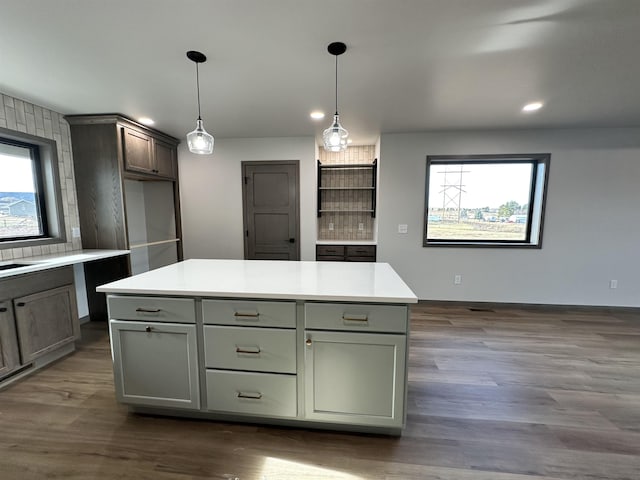 kitchen featuring a center island, decorative backsplash, dark hardwood / wood-style flooring, and decorative light fixtures