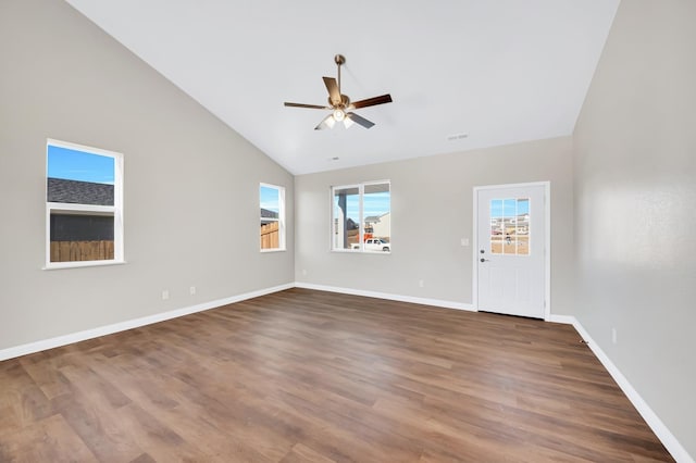 empty room with dark hardwood / wood-style flooring, high vaulted ceiling, and ceiling fan