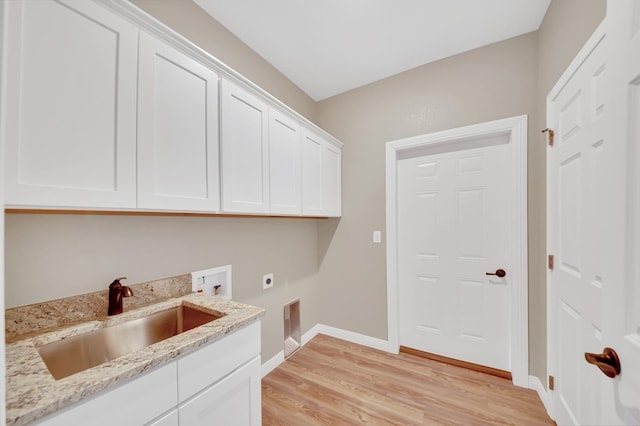 clothes washing area featuring cabinet space, a sink, light wood-style floors, washer hookup, and electric dryer hookup