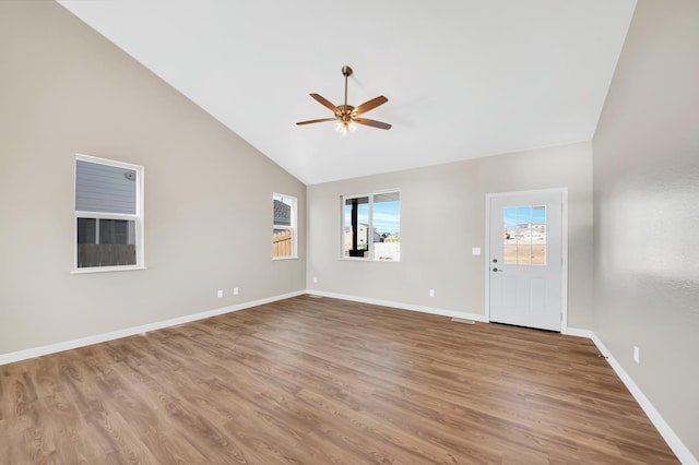 interior space featuring high vaulted ceiling, a ceiling fan, baseboards, and wood finished floors