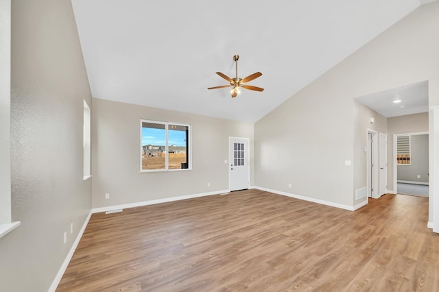 empty room with visible vents, light wood-type flooring, a ceiling fan, and baseboards