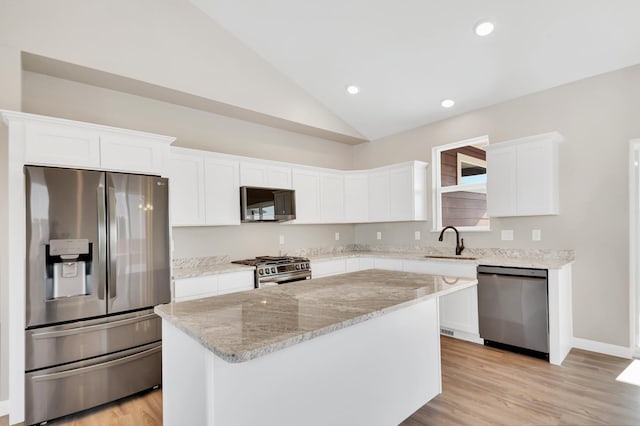 kitchen featuring stainless steel appliances, white cabinets, a sink, and a kitchen island