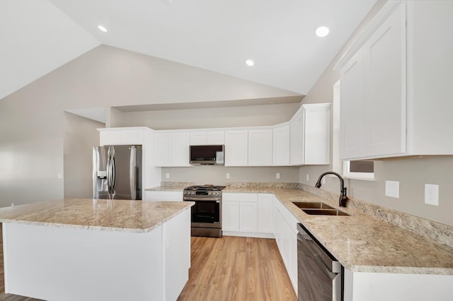 kitchen with white cabinetry, appliances with stainless steel finishes, a sink, and a center island