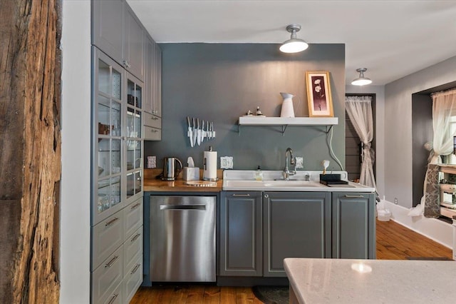 bar featuring sink, dark wood-type flooring, gray cabinets, wooden counters, and dishwasher