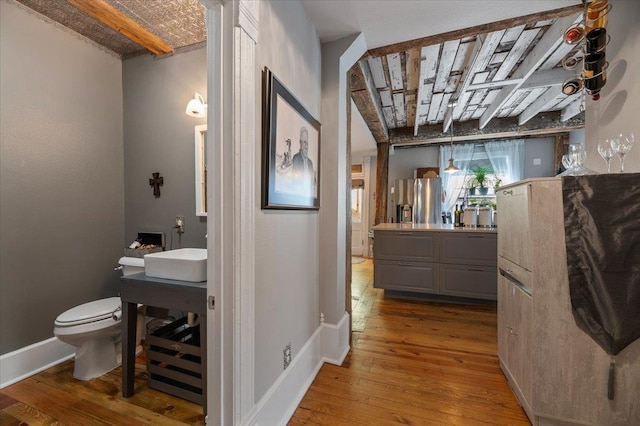 bathroom with hardwood / wood-style flooring, vanity, and toilet