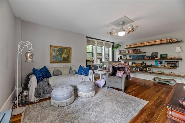 living room with dark wood-type flooring and ceiling fan