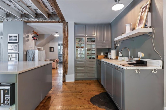 kitchen featuring gray cabinets, dishwasher, sink, light hardwood / wood-style floors, and kitchen peninsula